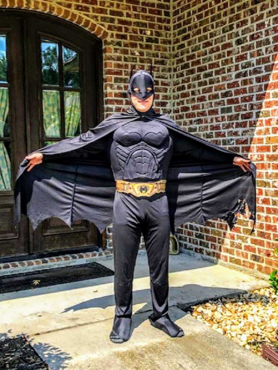older teen brother wearing a batman costume