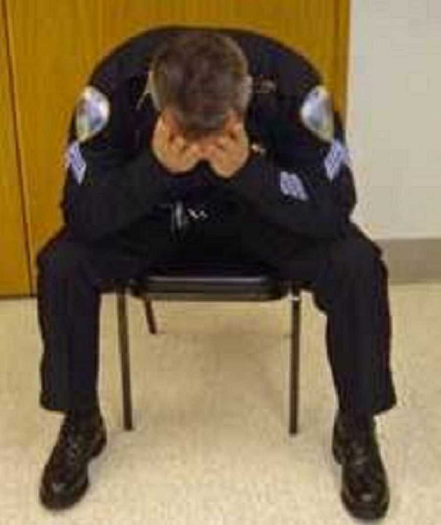 police officer sitting with head in hands