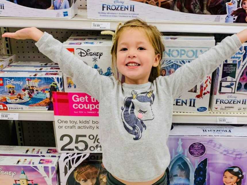 girl standing in front of toy shelf in store