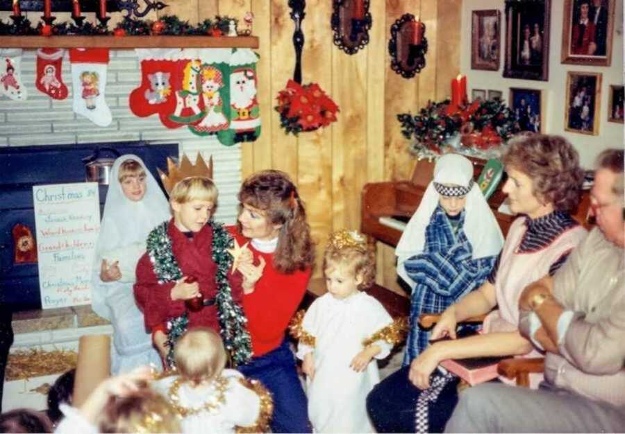 Family gathered around for Christmas in front of fireplace decorated with stockings