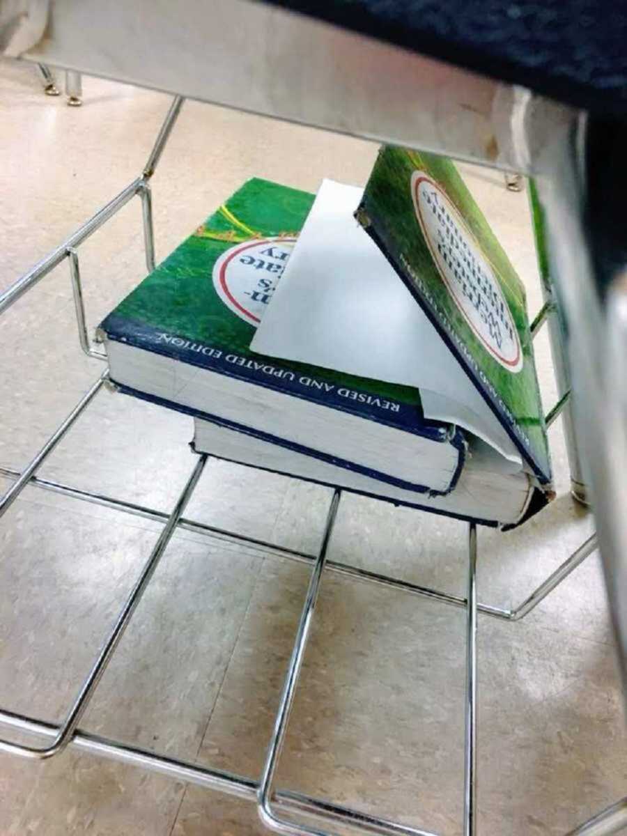 Two green Merriam-Webster's dictionaries under school desk