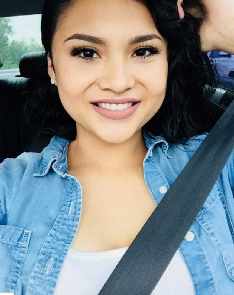 Woman in denim button down smiling in driver's seat