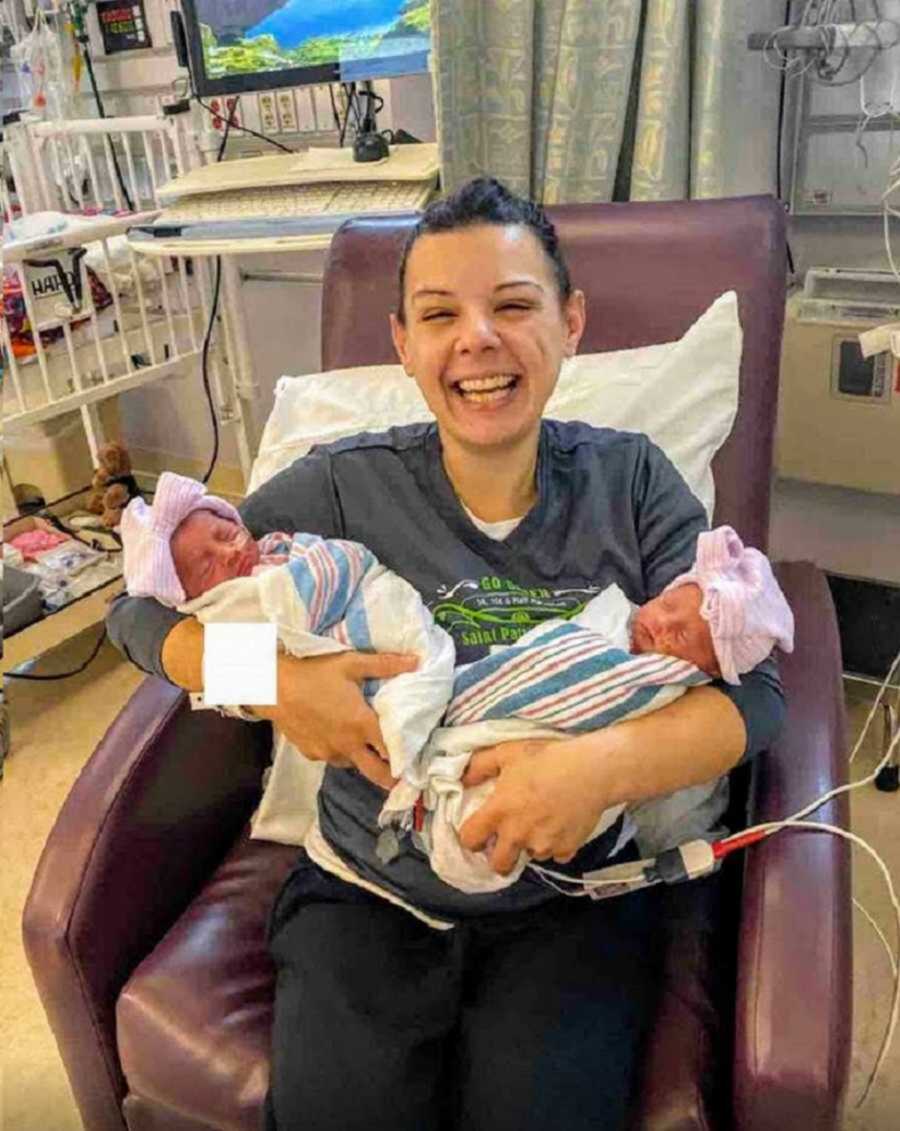 woman in hospital holding newborn twins