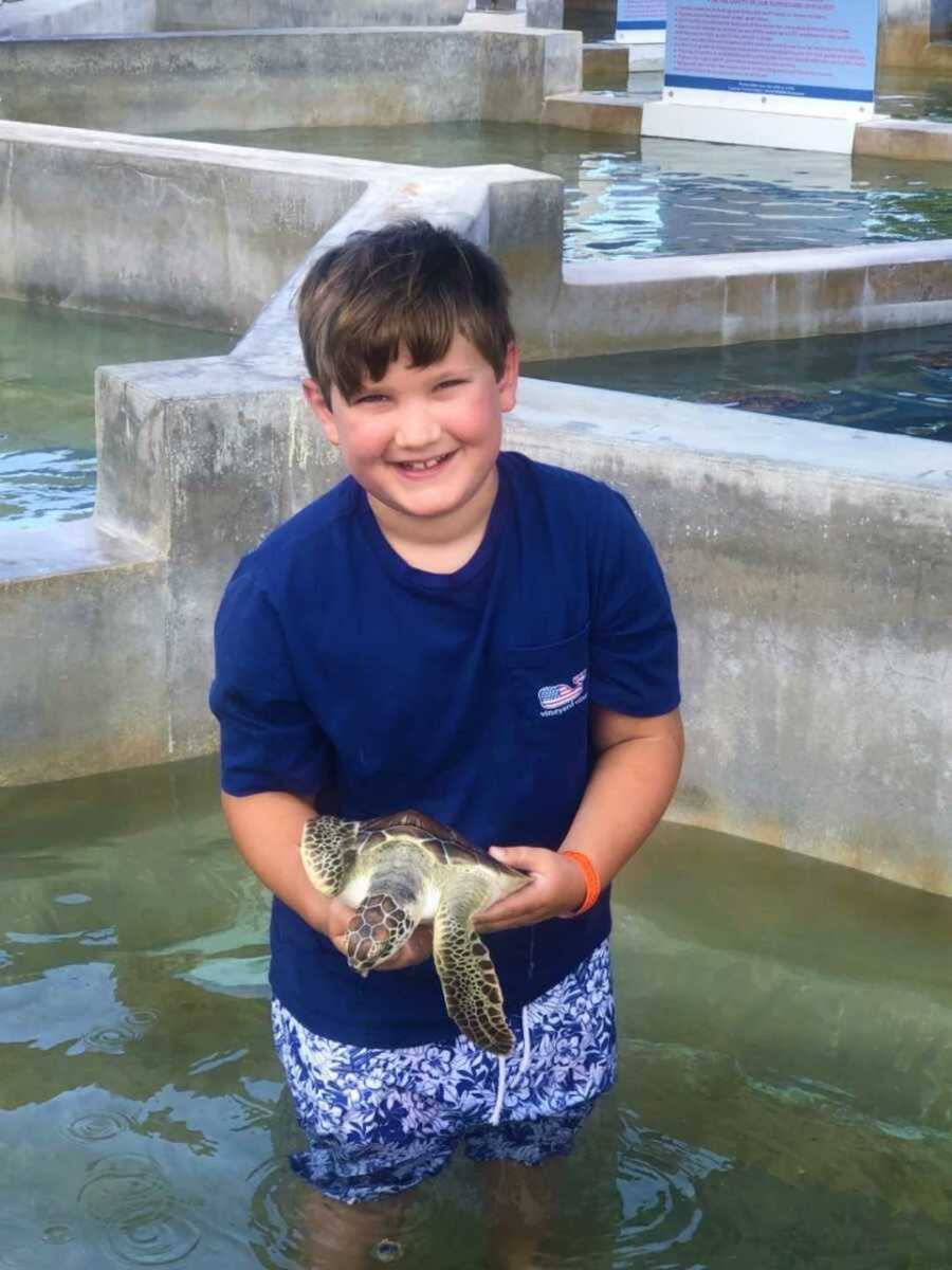 boy holding turtle at aquarium
