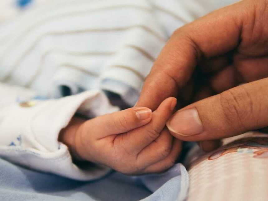 Parenting holding newborn's finger