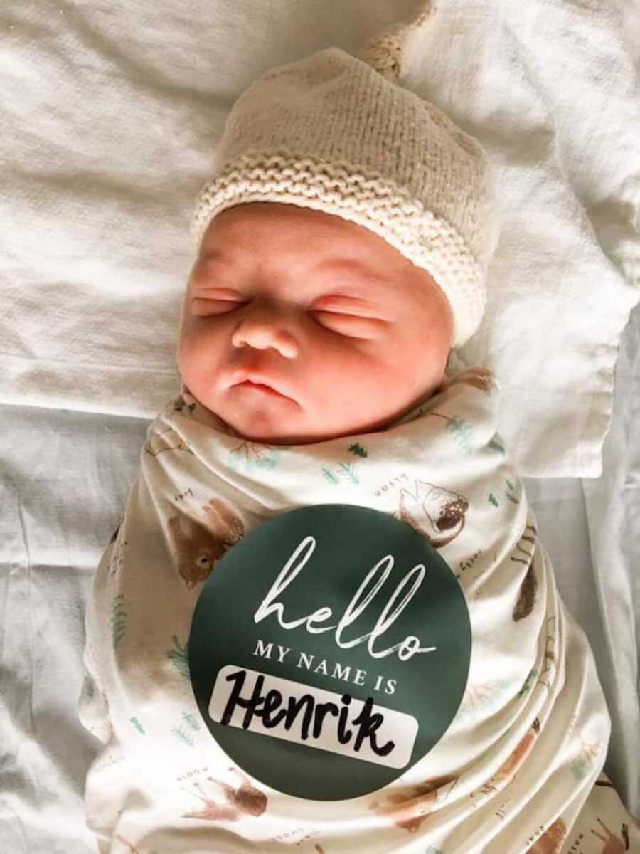 baby with down syndrome in white hat