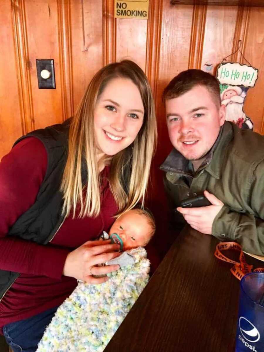 parents holding baby with down syndrome