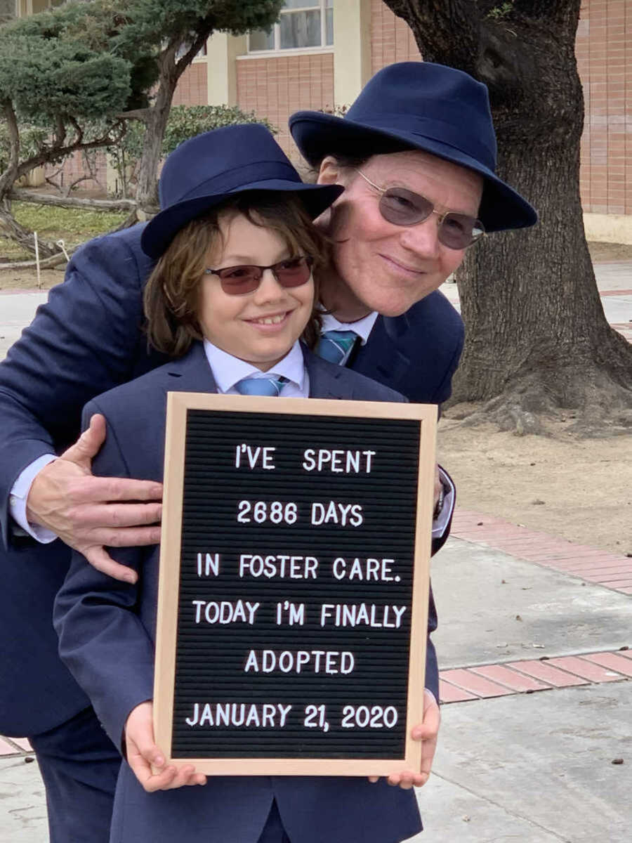 Boy holding adoption announcement sign