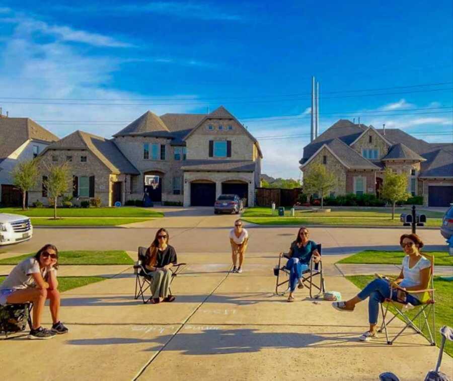 Best friend sitting in chairs on driveway pavement