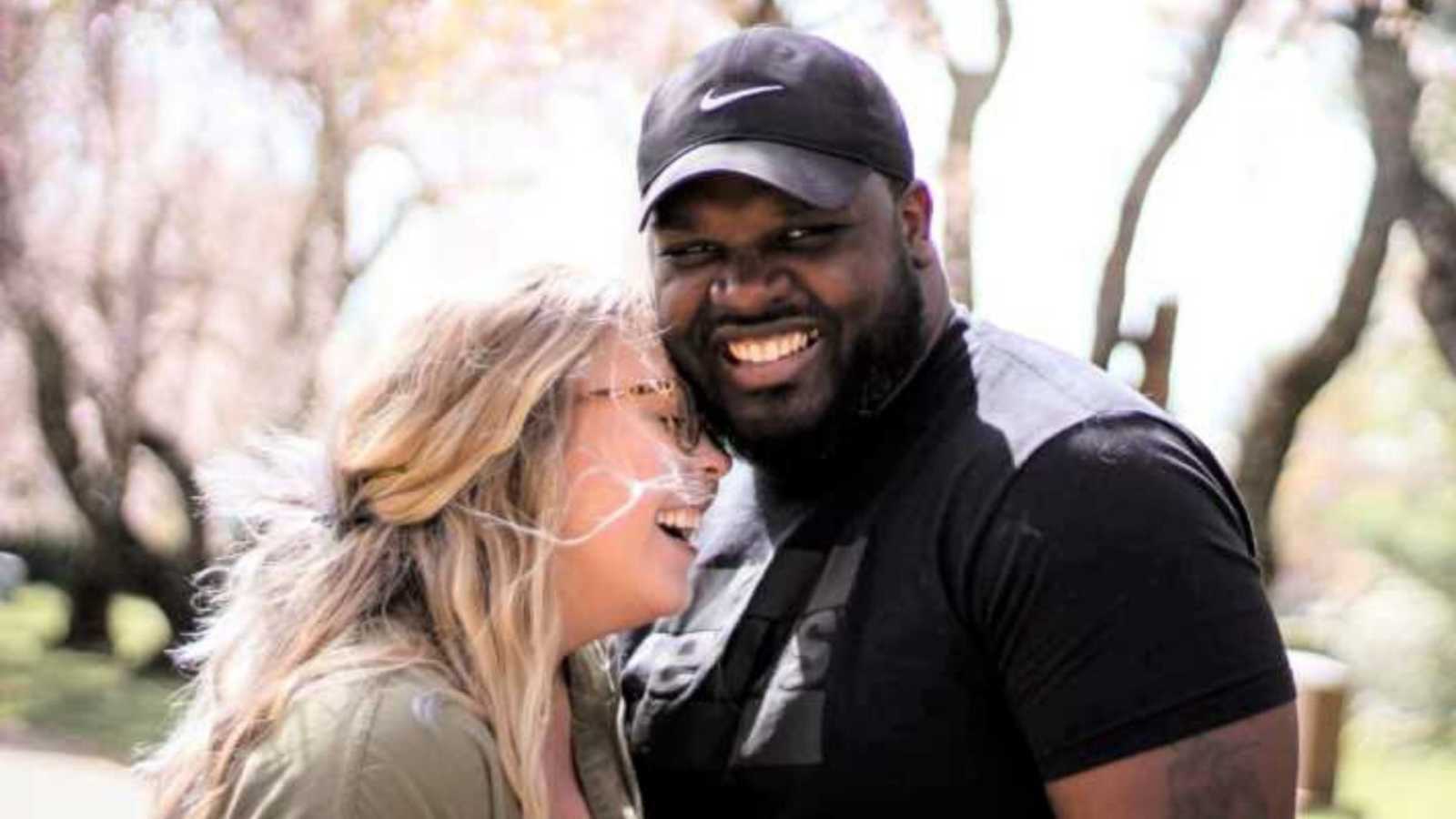 interracial couple smiling in park