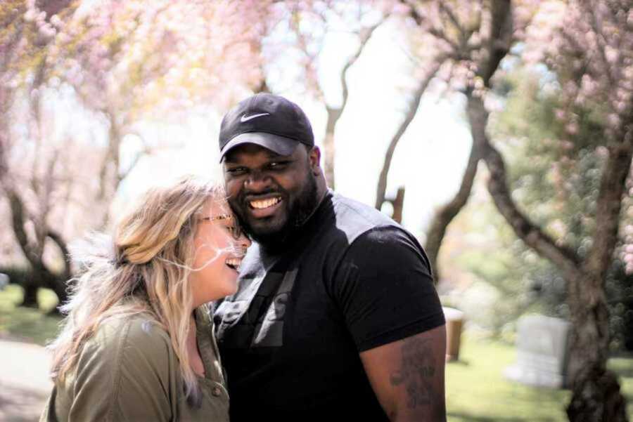 interracial couple smiling in park