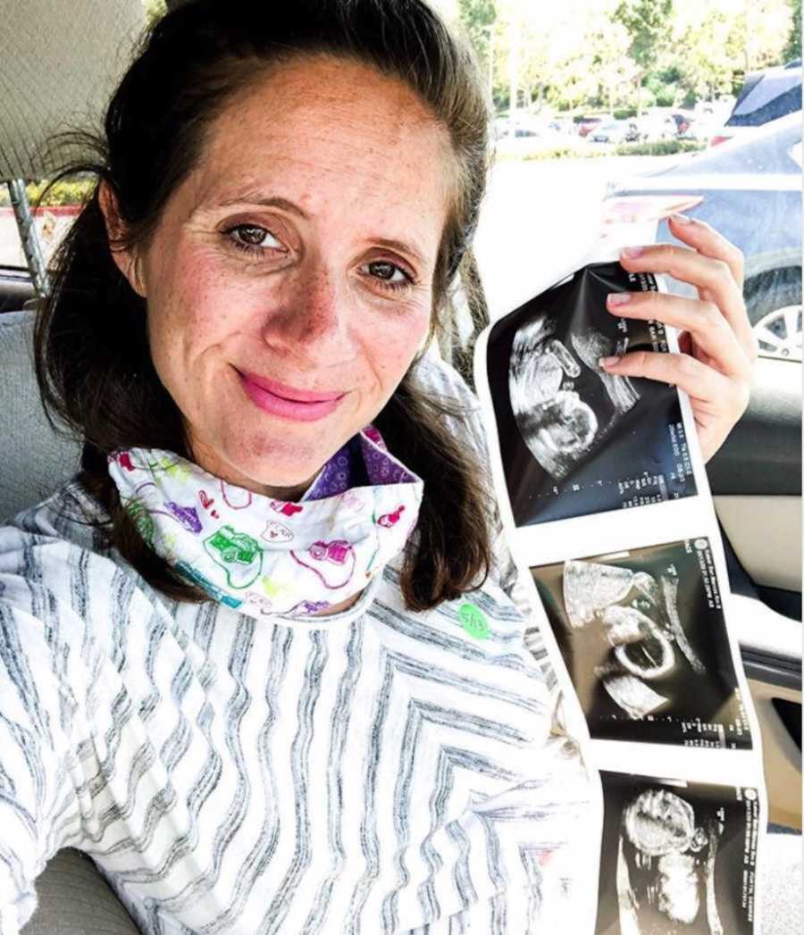 mom holding ultrasounds in car