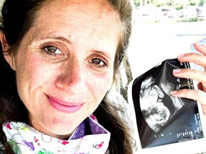 mom holding ultrasound in car