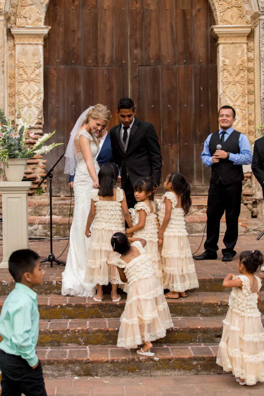 Bride embracing foster child during Guatemalan wedding ceremony
