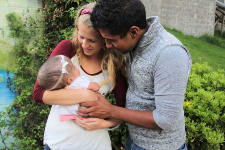 Couple holding newborn girl with special needs