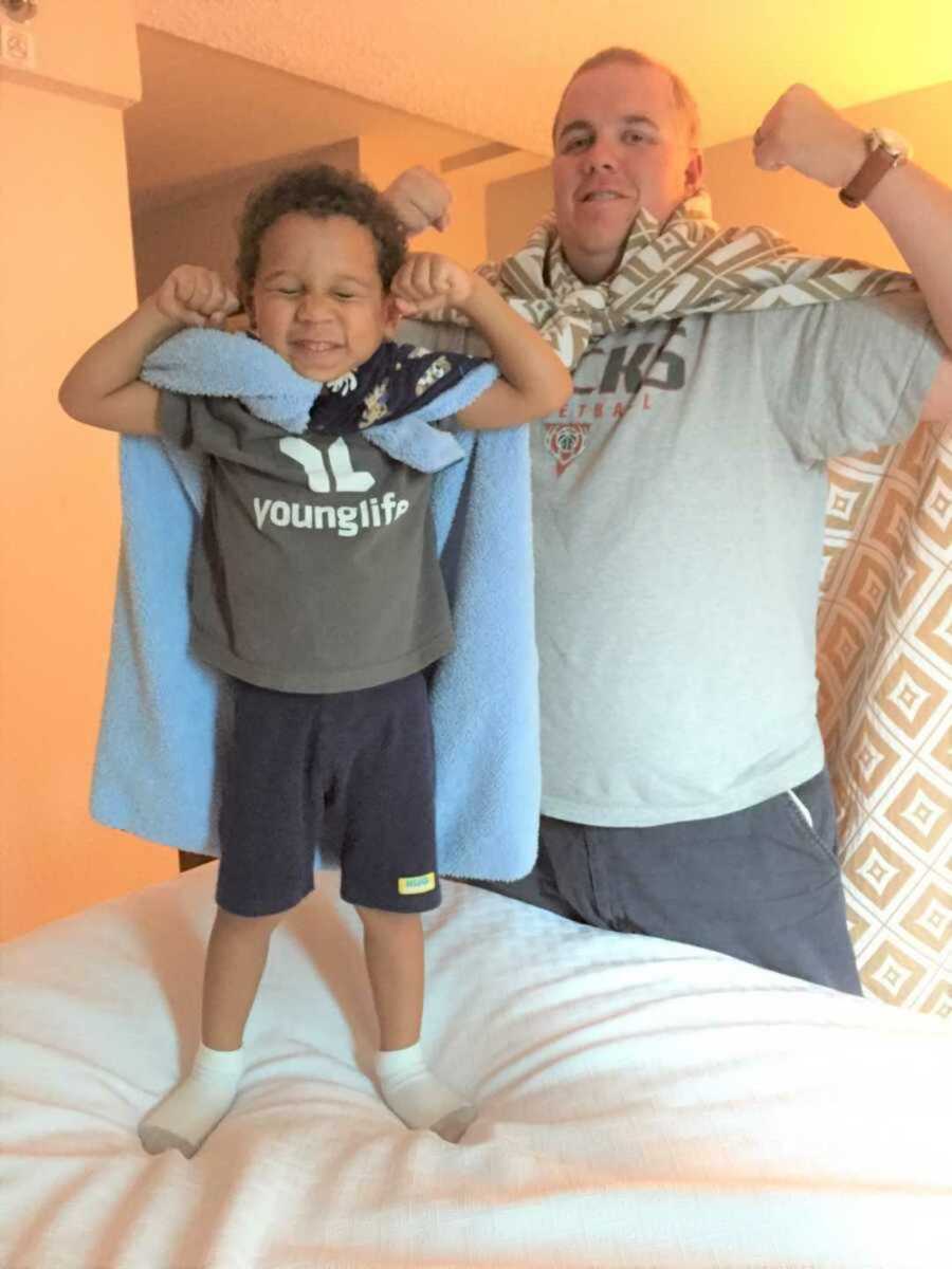 Foster dad and son smiling while flexing muscles