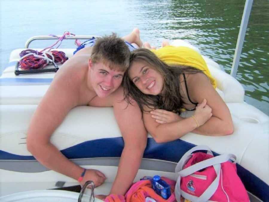 Teen boyfriend and girlfriend lying on boat