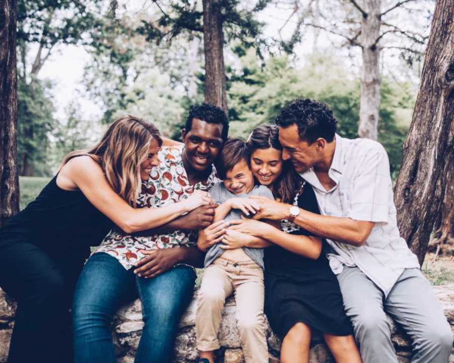 Smiling Family Gathering Together With Adopted Brother