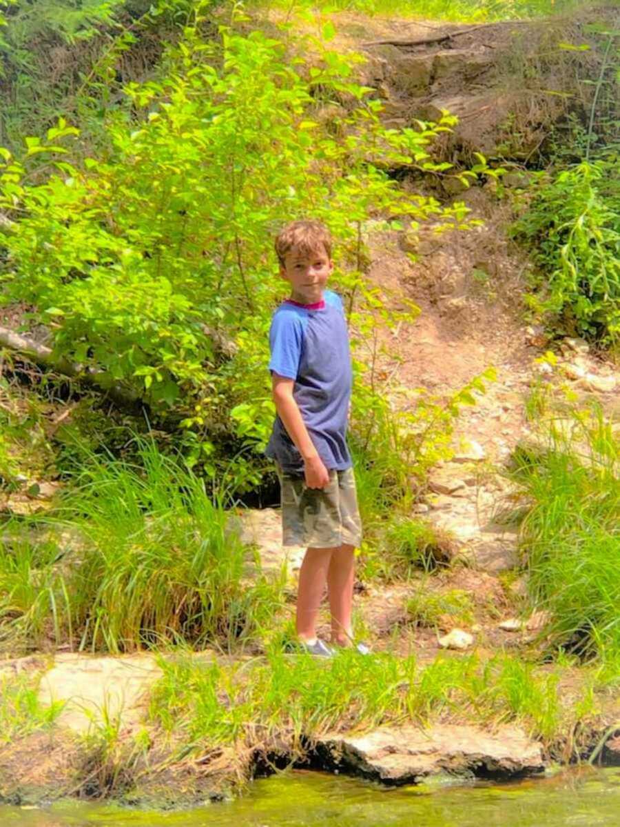 boy smiles outside on a trail