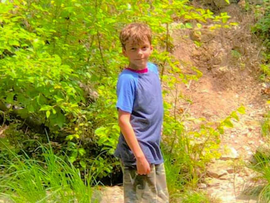 boy standing outside on trail