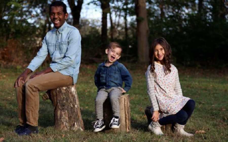 Joyful Adopted And Biologcal Siblings Sitting On Tree Stumps