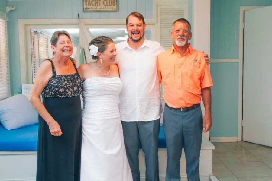 bride smiles with brother and parents