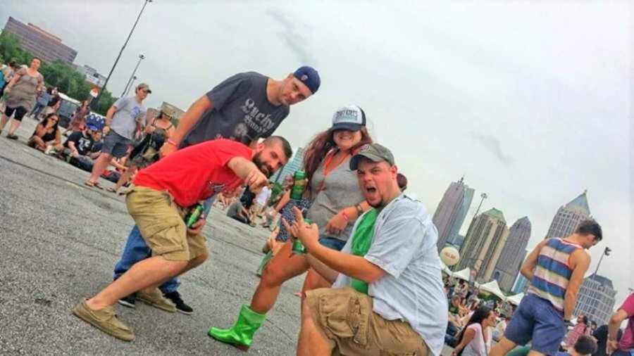 four friends posing for camera in street