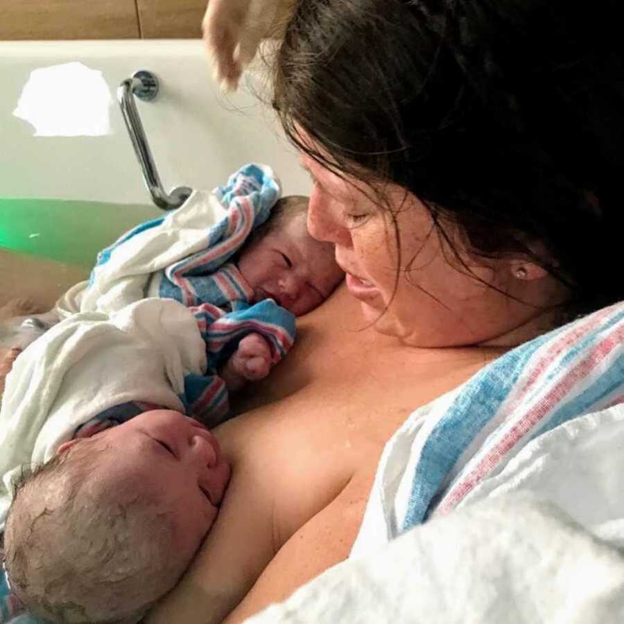 Mom holds newborn twin girls to chest