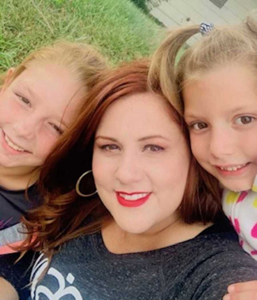 Adoptive mom smiling with two daughters