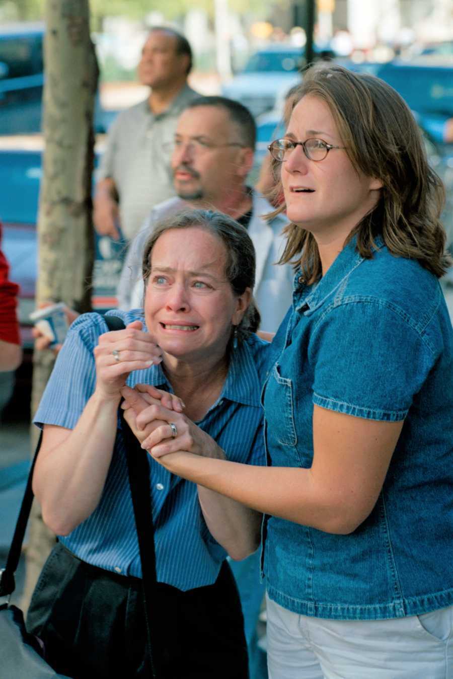 Two women look terrified watching as the towers are crashed into