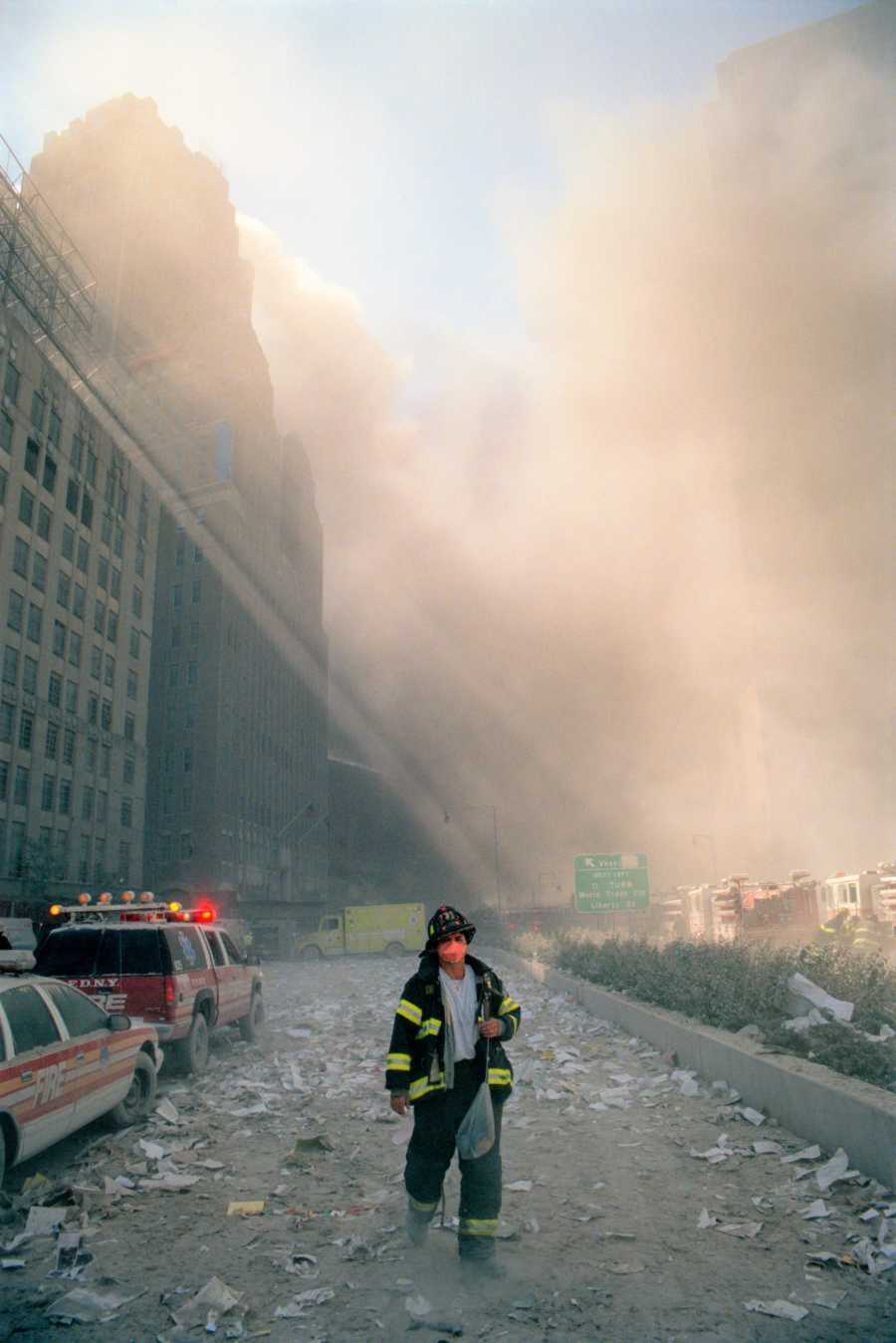 First responder trudges through the smoke as the towers burn