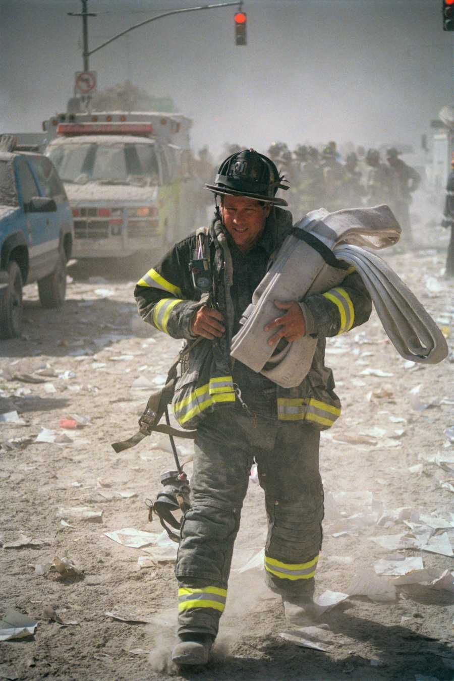 Firefighter runs through debris and smoke as he holds supplies for water