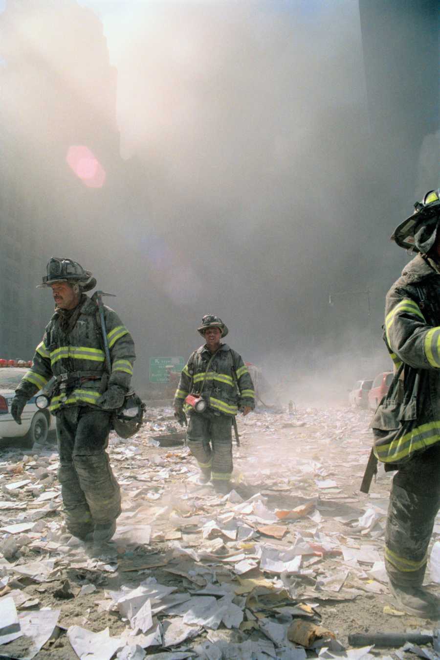 Three firemen walk amongst the smoke that the crash created