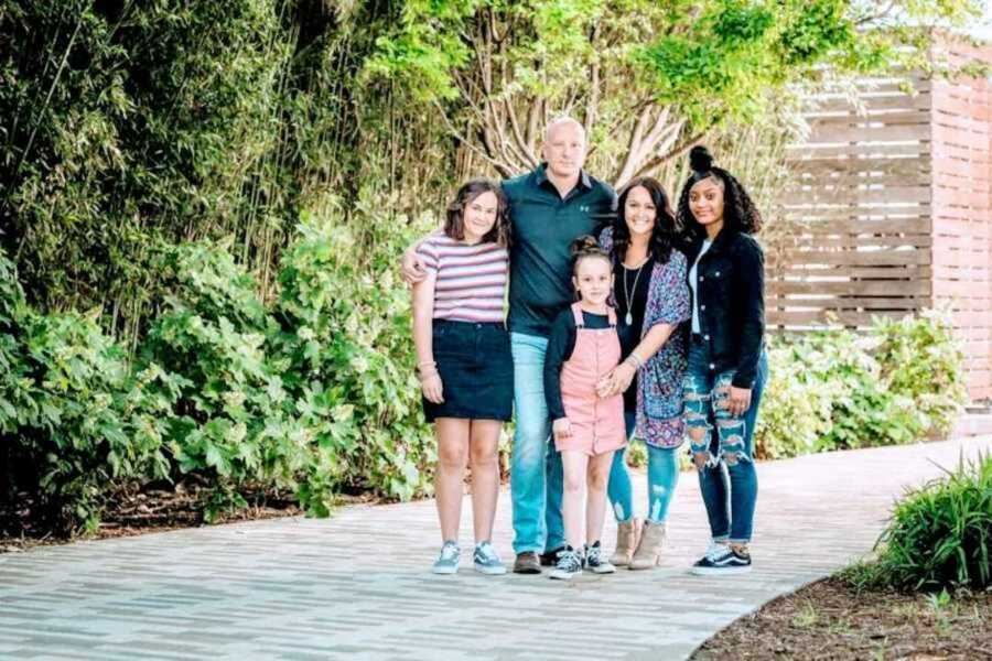 Adoptive family posing in driveway