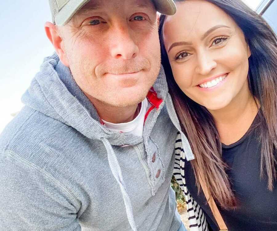 Husband and wife smiling in selfie outside car