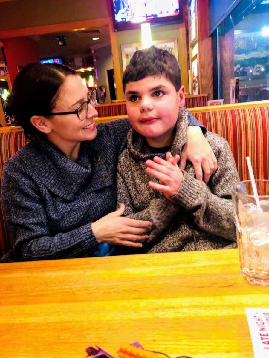 Mom holding son with autism at Beef Barn restaurant booth