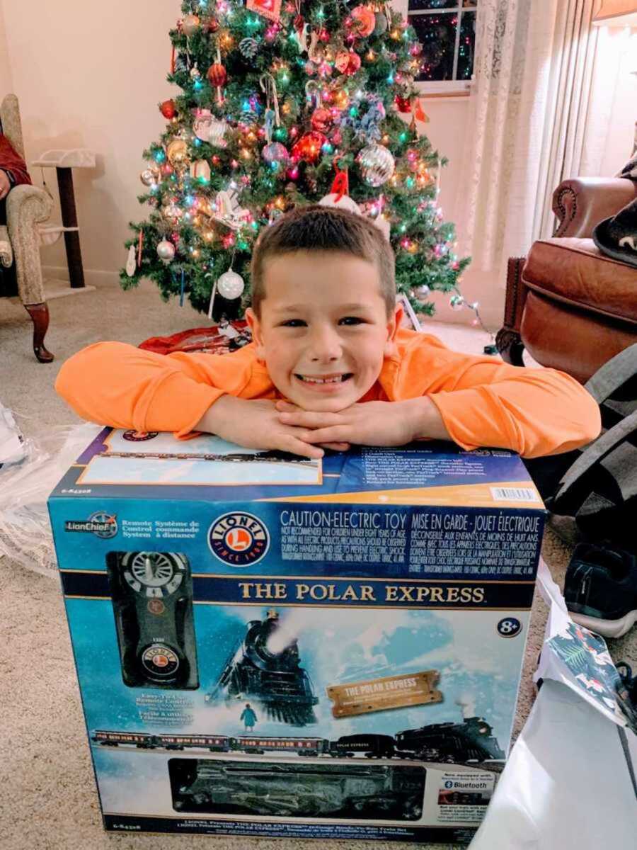 Little boy smiling with his brand new toy train