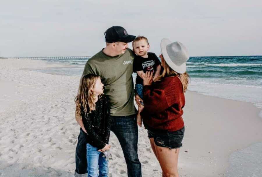 Family embracing on white-sand beach