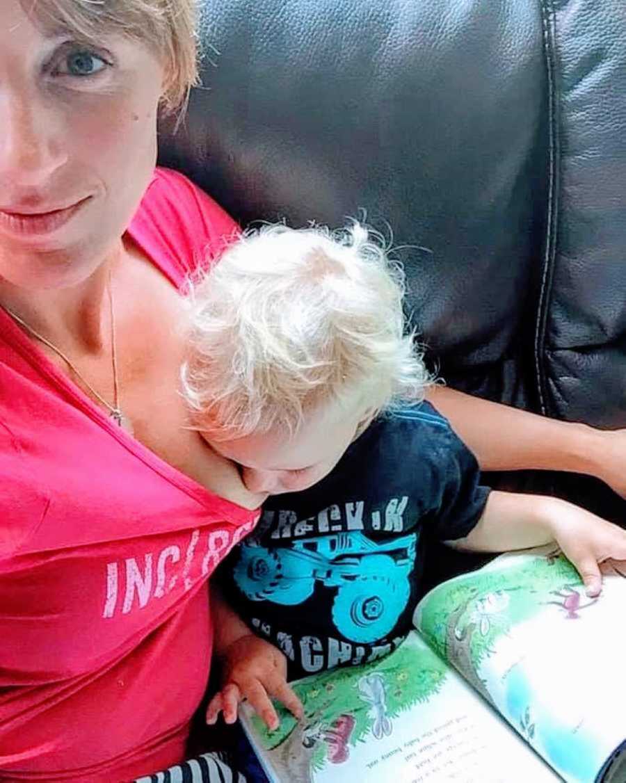 mom takes a selfie while breastfeeding her son while he reads a book