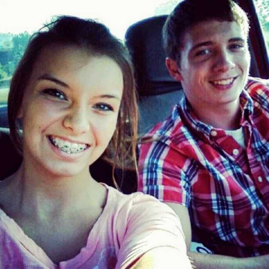 Teen couple taking selfie in car