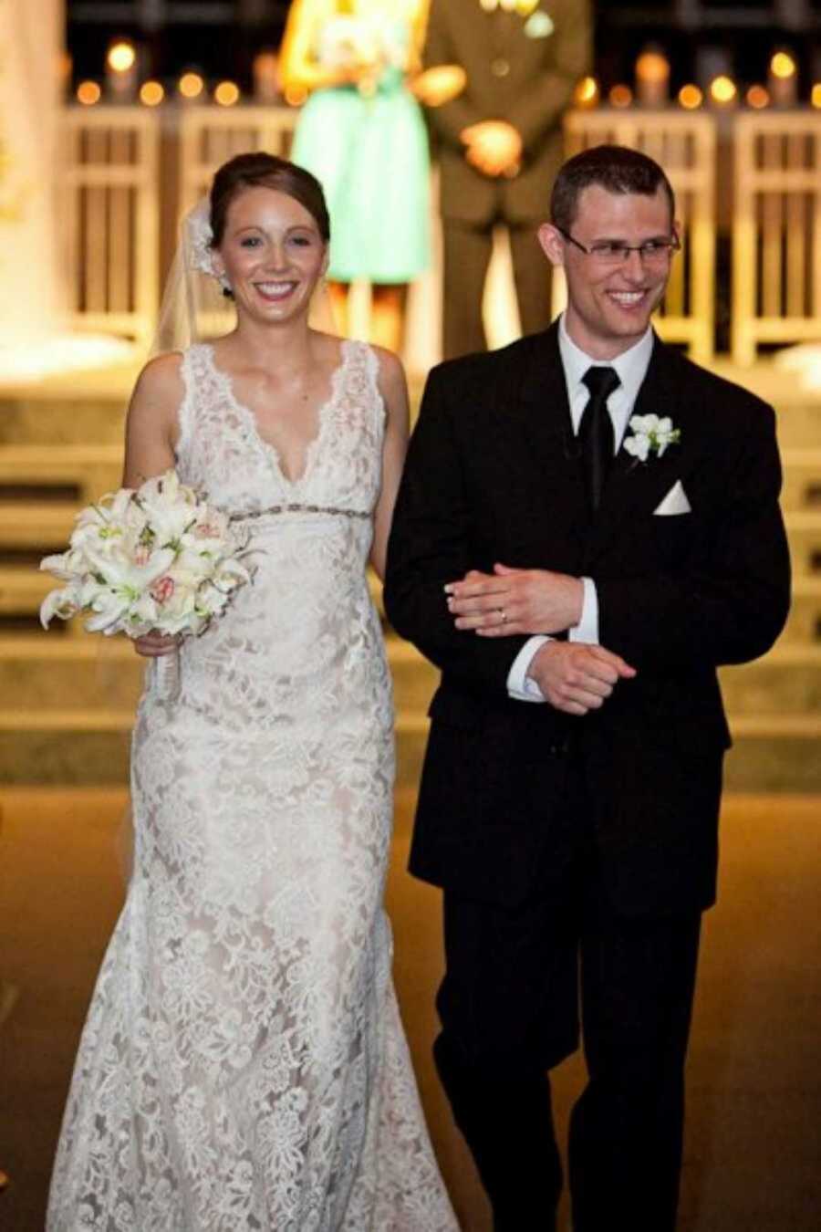 Newly wed couple smile as they walk down the aisle after exchanging their vows