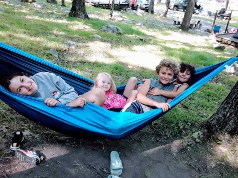 Young friends sitting in tree hammock