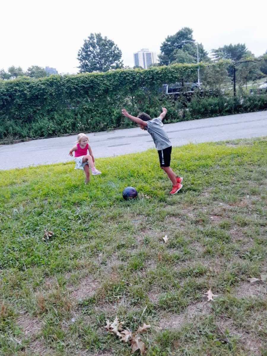 Girl with Down syndrome playing soccer with neighborhood friend