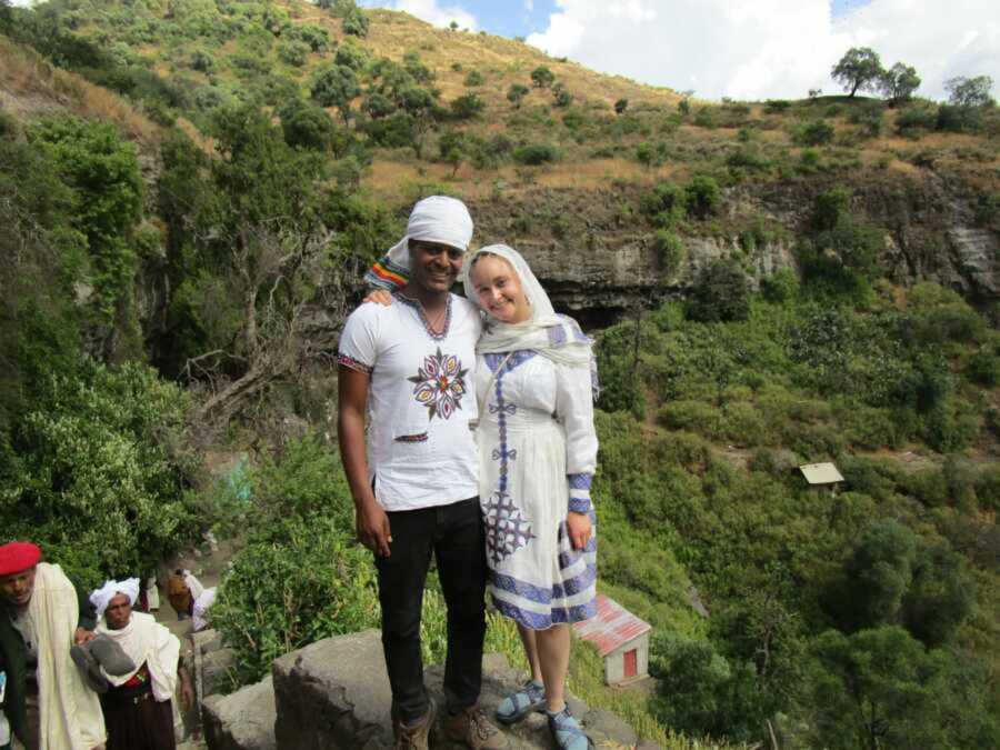 Couple smiling together in forest with traditional clothing on