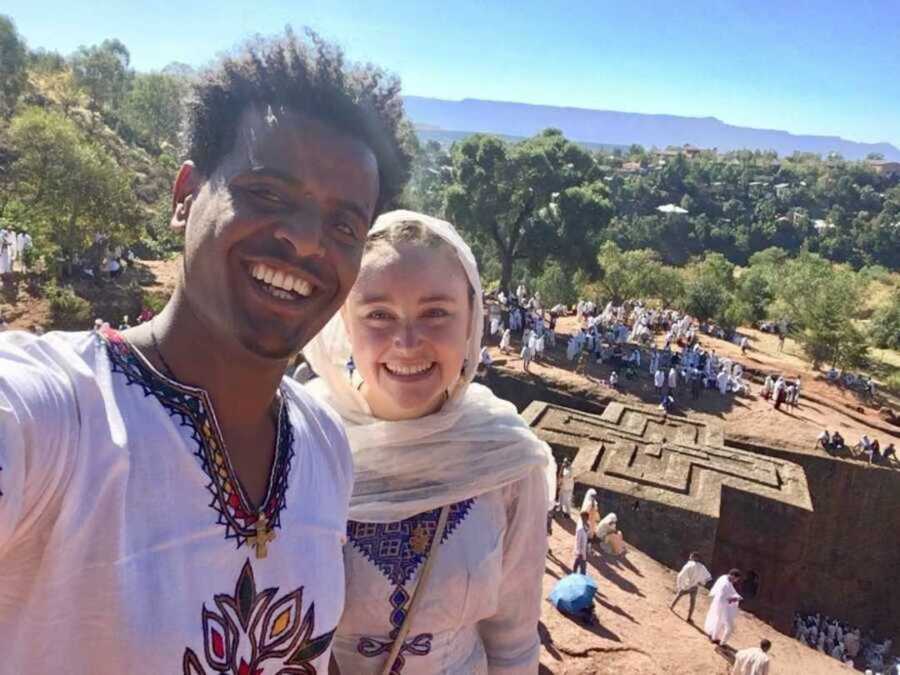 Couple beams as they take a selfie together in traditional clothing