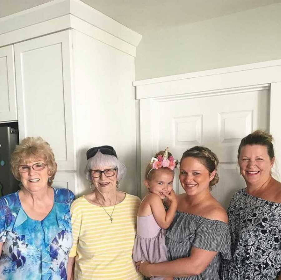 grandma stands with multiple generations of women