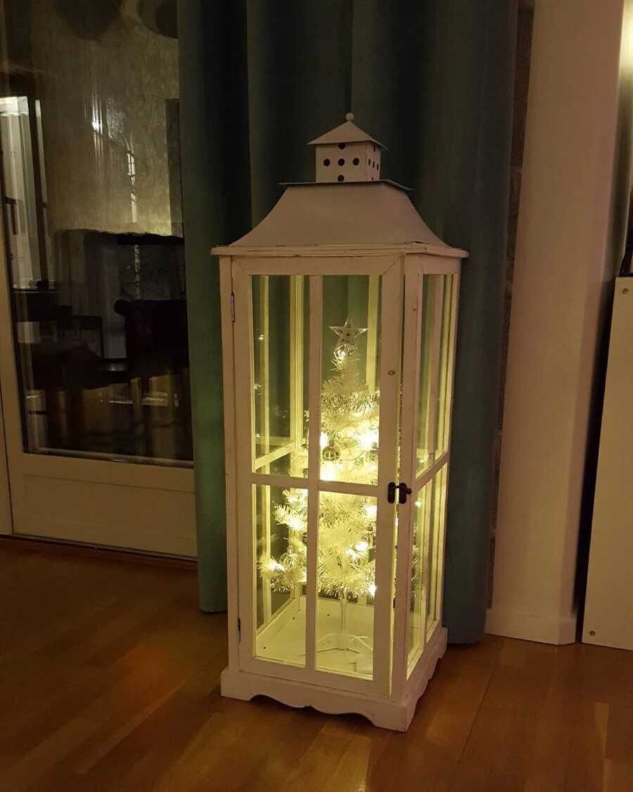 White lit up Christmas tree inside of a case 