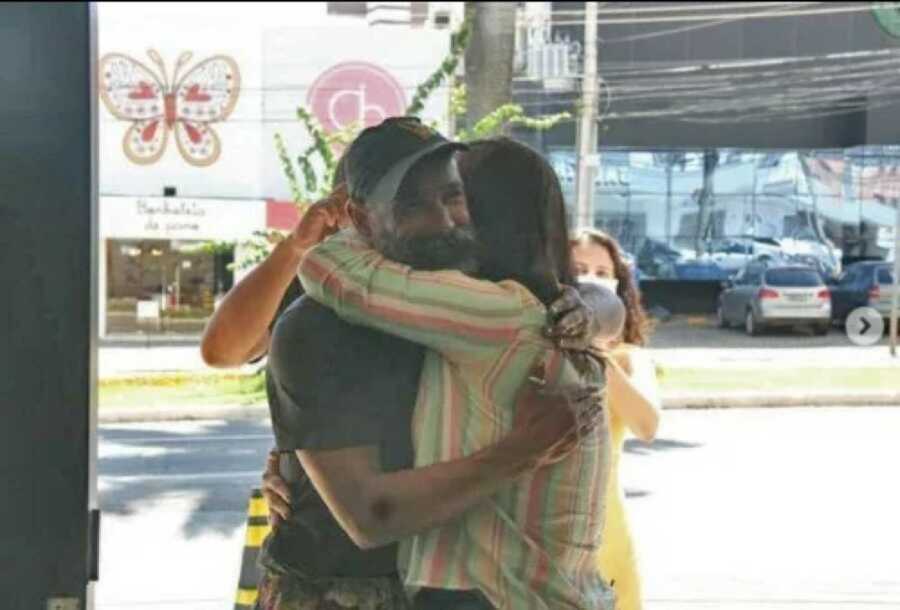 homeless man reuniting with his sister as they hug
