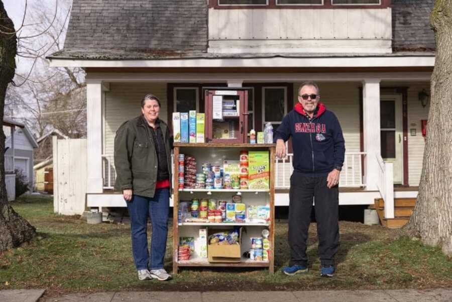 couple standing next to outdoor food pantry
