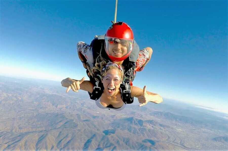 excited young woman skydiving with a lprofessional 